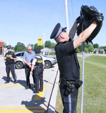 South Bruce OPP acting-sergeant Kevin Martin (right), community services officer, unveils a second Project Safe Trade sign in Kincardine